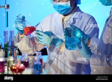 Group Of Chemists Wearing Safety Goggles And White Coats Studying