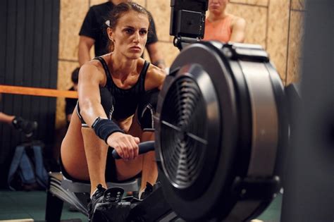 Premium Photo Front View Sportive Woman Doing Exercises On Rowing