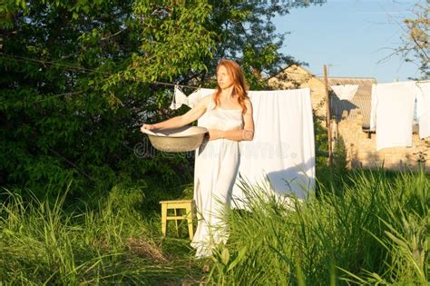 Beautiful Red Girl In Nightie Hanging Laundry Outdoors Village Woman