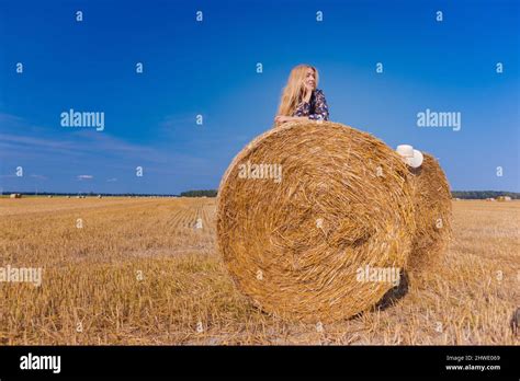 Une Jeune Fille Blonde Aux Cheveux Longs Dans Un Chapeau Blanc Se Repose Et Pose Pr S Des Gerbes