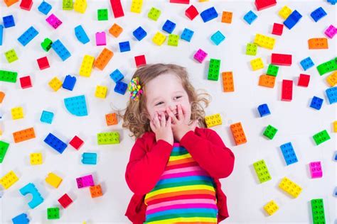 Menina Que Joga Blocos De Madeira Do Brinquedo Foto De Stock