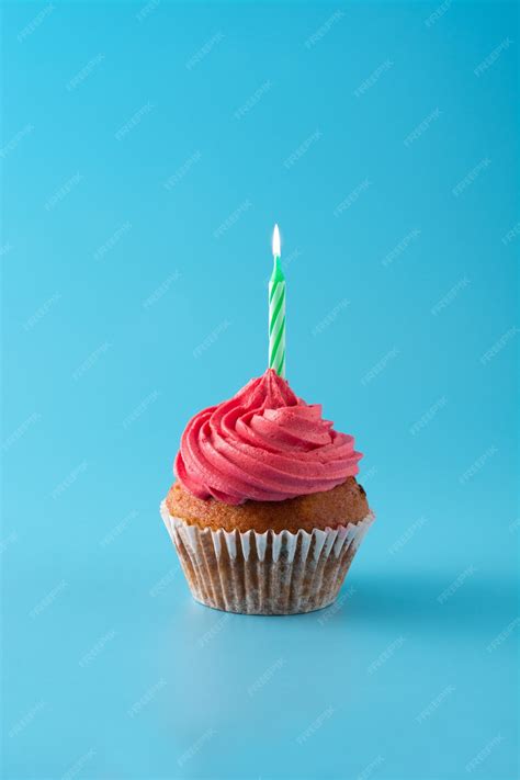 Premium Photo Pink Birthday Cupcake With Green Candle On Blue Wall