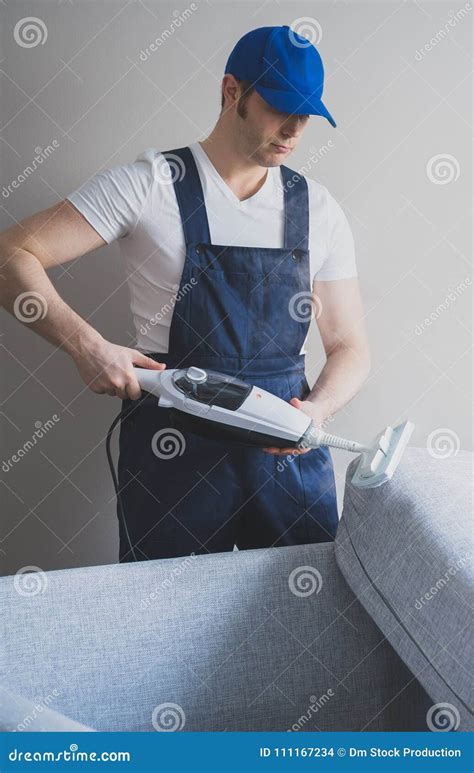 Man In Uniform Cleaning Fabric Of The Sofa Stock Photo Image Of