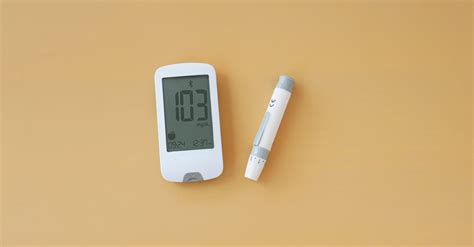 A digital blood glucose meter on a yellow background · Free Stock Photo