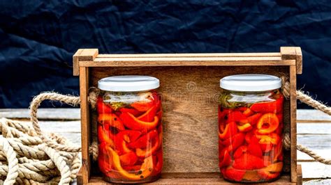 Wooden Crate With Glass Jars With Pickled Red Bell Peppers Preserved