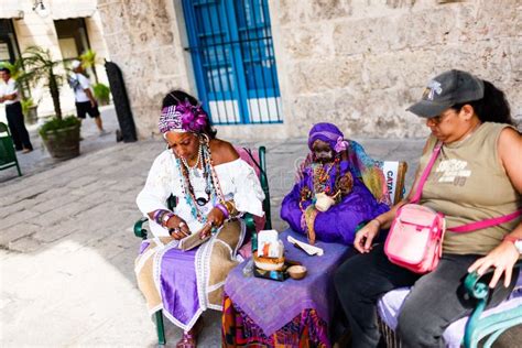 Dark Skinned Cuban In White Costume Tells Fortunes To Tourists In