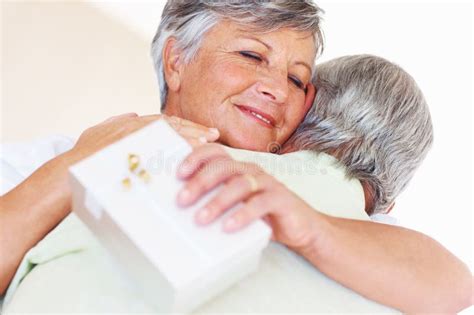 Mature Couple Hugging After Sharing Gift Closeup Of Happy Mature Woman Hugging Man After