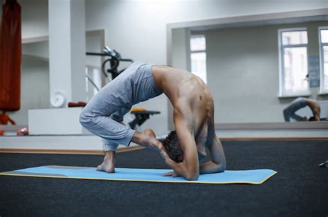 Atlético joven musculoso trabajando yoga pilates entrenamiento