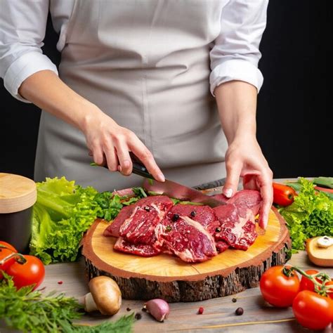 El Chef Corta La Carne En Filetes Sobre Una Tabla De Madera Diferentes