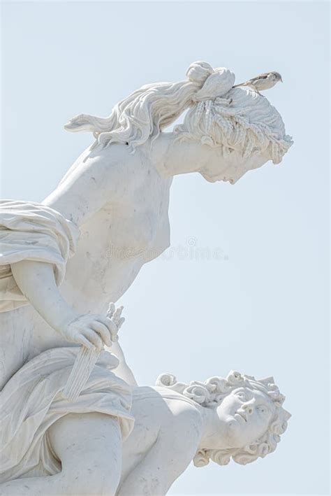Old Statue Of A Sensual Naked Renaissance Era Women With A Bird Sparrow At The Head In The City
