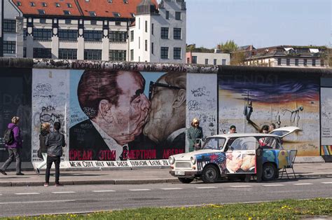 Germany Berlin Trabant In Front Of Mural Painting Of Brotherly Kiss