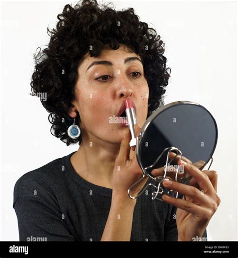 Woman putting on lipstick Stock Photo - Alamy