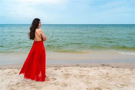 Happy Woman In Red Dress Standing With Arms Crossed On Sea Beach Stock