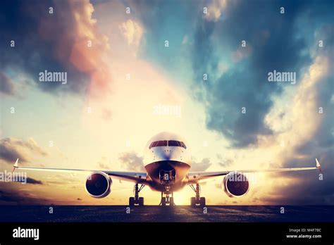 Passenger Airplane Taking Off On Runway At Sunset Stock Photo Alamy