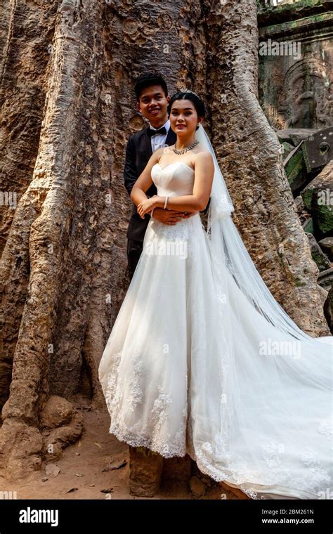 A Cambodian Couple Having Their Wedding Photos Taken At Ta Prohm Temple