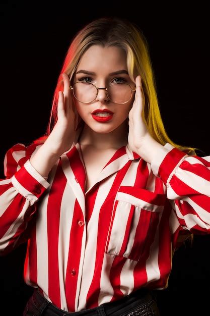 Premium Photo Stylish Blonde Girl In Glasses Wearing Striped Blouse Posing With Red And