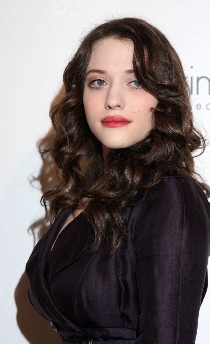 a woman with long dark hair wearing a black dress and red lipstick is posing for the camera