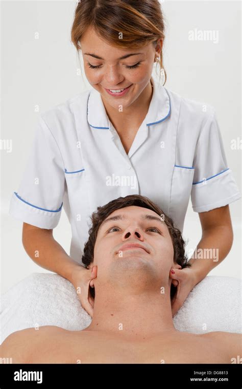 Young Female Osteopath Doctor Treating Young Male With Neck Pain Doing