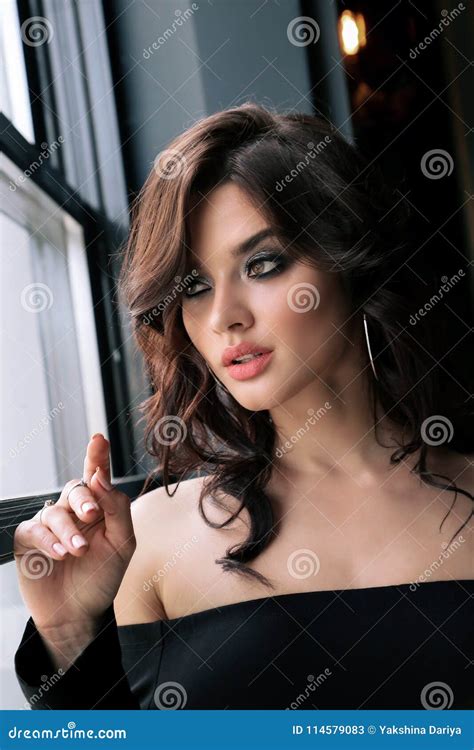 Sensual Woman With Dark Curly Hair In Elegant Clothes Sitting In Stock