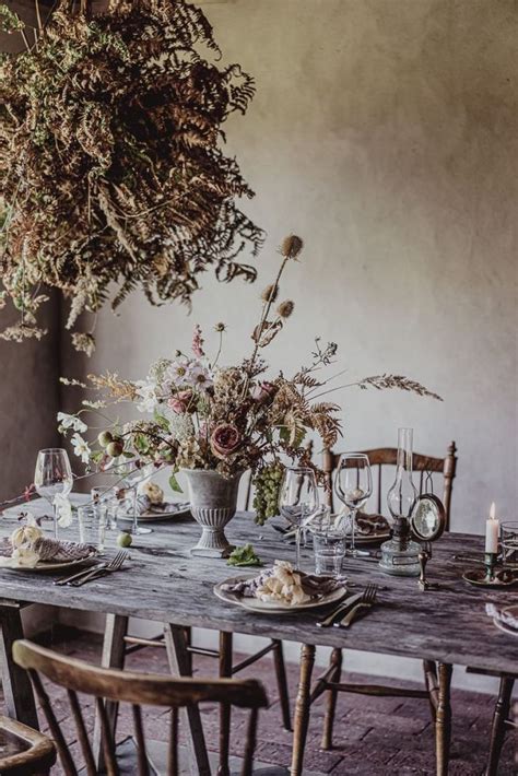 A Wooden Table Topped With Lots Of Plates And Glasses Next To A Vase