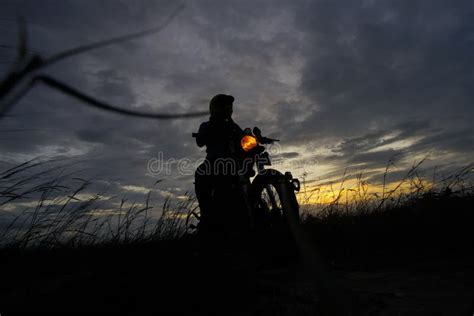 Silhouette Of A Man Riding His Motorcycle During Sunset Stock Photo