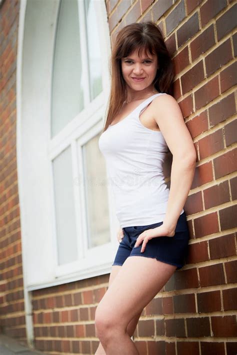 Brunette Divertida Linda Chica Cerca De La Pared Con Ladrillo Rojo En La Parte Central De La