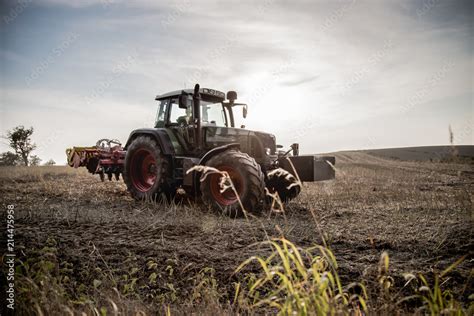 Traktor na polu o zachodzie słońca Stock Photo Adobe Stock