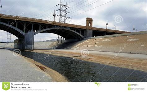 The Los Angeles River With Bridge And Dark Sky In The Background Stock