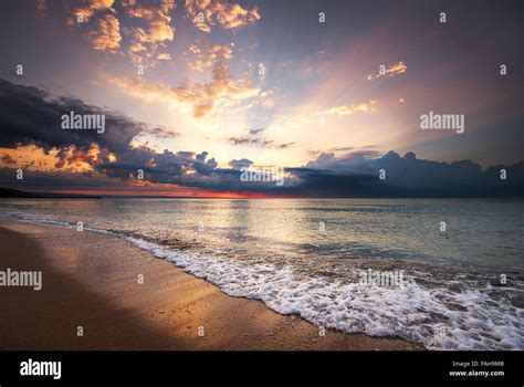 Colorful Ocean Beach Sunrise With Deep Blue Sky And Sun Rays Stock