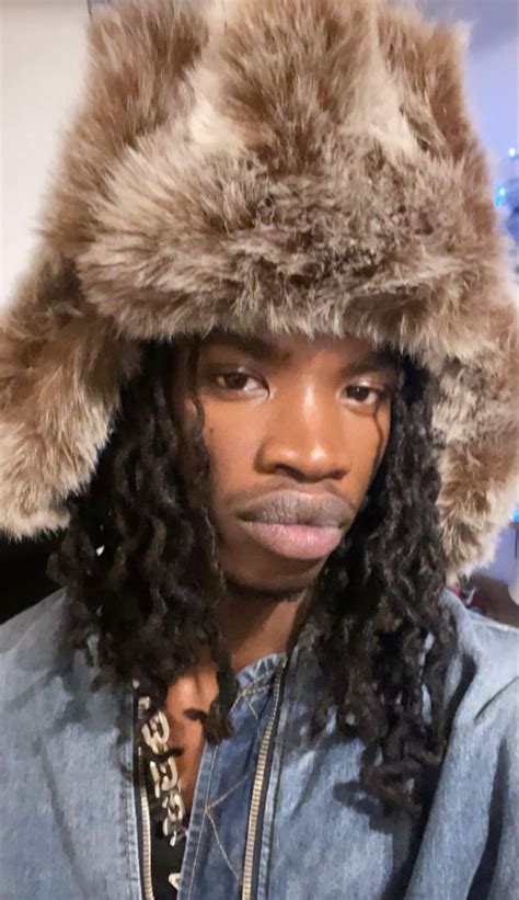 A Man With Long Hair Wearing A Fur Hat On Top Of It S Head