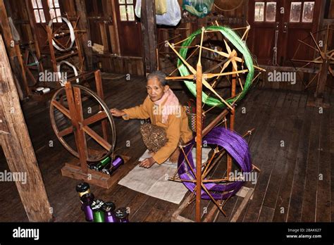 A Senior Burmese Woman Working At A Vintage Hand Loom In A Village