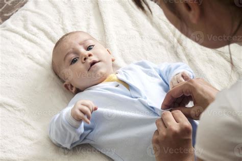 Mother is changing her baby's clothes 949341 Stock Photo at Vecteezy