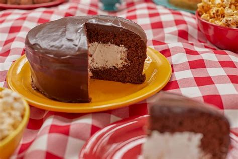 A Piece Of Chocolate Cake On A Plate Next To Bowls Of Popcorn And