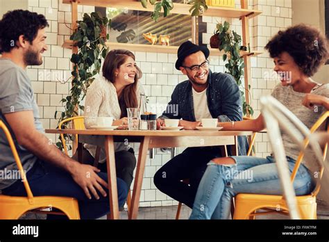 Young People Having A Great Time In Cafe Friends Smiling And Sitting