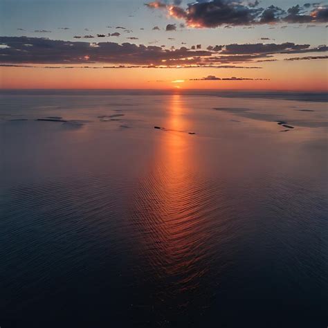 Premium Photo | A sunset over the ocean with a boat in the water