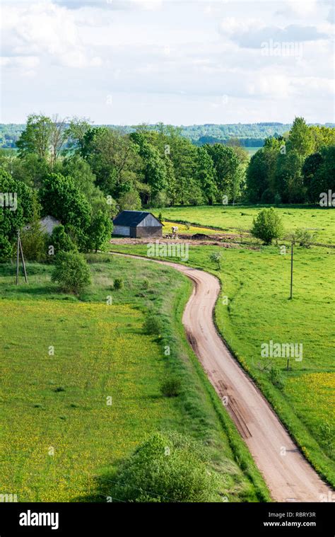 Country Gravel Road In Perspective With Old And Broken Asphalt In