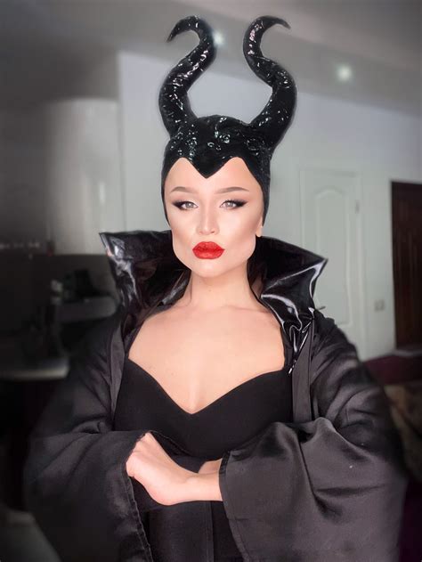 A Woman In A Black Dress With Horns On Her Head