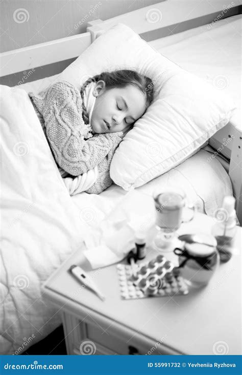 Black And White Portrait Of Sick Girl Sleeping In Bed At Home Stock