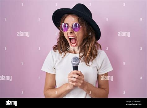 Beautiful Brunette Woman Singing Song Using Microphone Angry And Mad Screaming Frustrated And