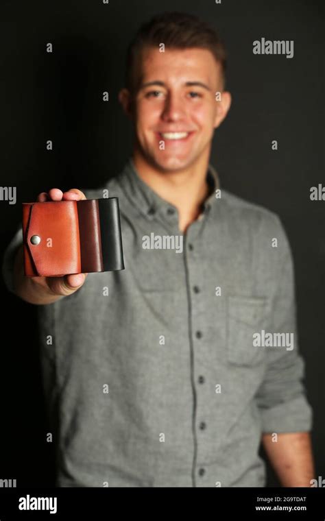 Man Holding Hand Made Leather Wallets On Black Background Stock Photo