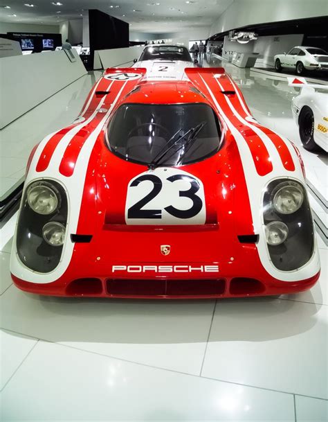 A Red And White Race Car On Display In A Showroom