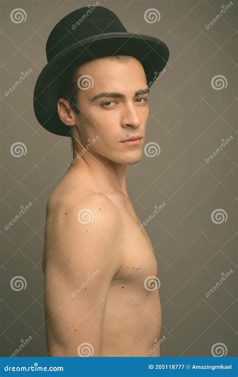 Joven Y Guapo Hombre Sin Camisa Contra Fondo Gris Imagen De Archivo