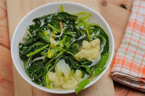 Premium Photo | Sayur bening bayam or spinach clear soup with broccoli in a white bowl and wooden