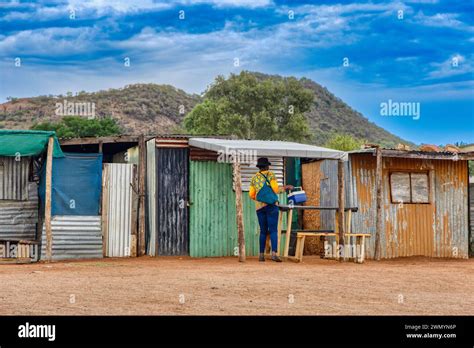 Township Informal Settlement In Africa Near A Hill Woman Caring A