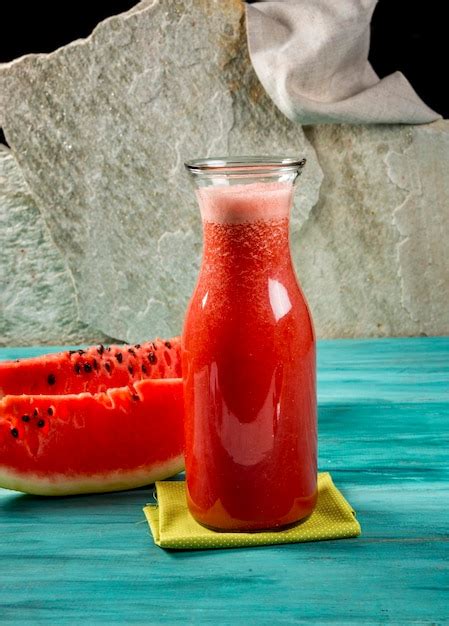 Suco De Melancia Em Garrafa E Duas Fatias De Melancia Em Madeira Azul E