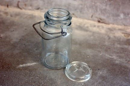 A Glass Jar With A Lid Sitting On The Ground