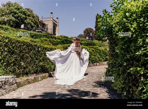 Brunette gère un parc de robes blanches Une belle femme avec de longs cheveux bruns et une