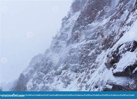 Costa Rochosa De Um Rio Do Inverno Durante Uma Tempestade De Neve Foto