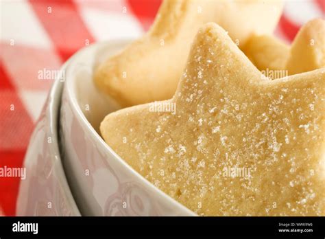 Sugar Coated Shortbread Cookies In Star Shapes Stacked Up On A White