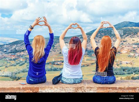 Vacation And Tourism Concept Three Girls Brunette Blonde And Redhead Sit With Their Backs
